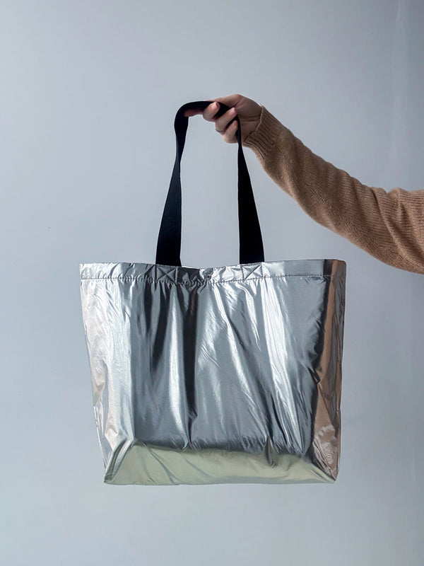 Silver eco tote bag made of glossy material - stylish shopper with black handles for city looks and shopping